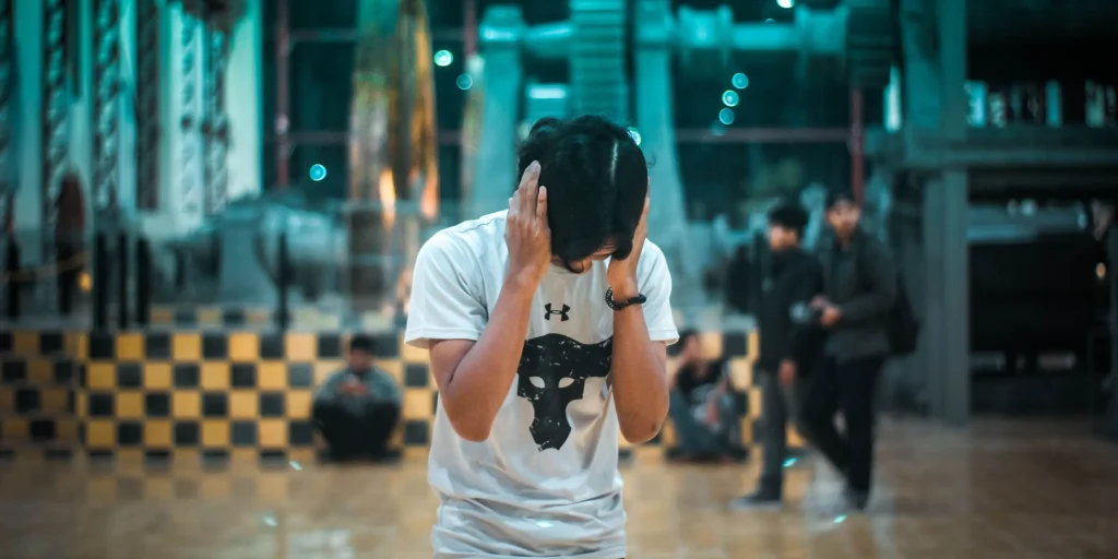 guy holding his ear because of loud noise